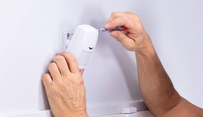 Professional worker installing motion sensor