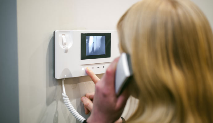 woman using intercom telephone