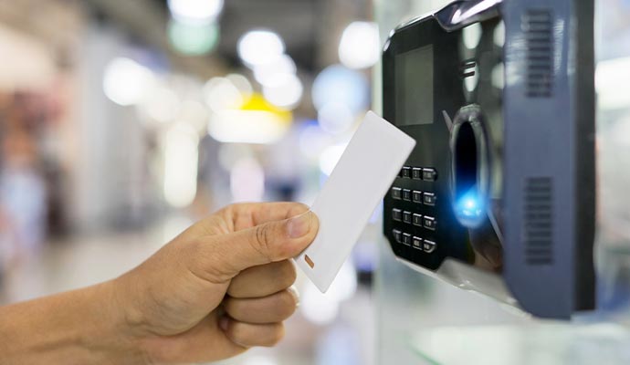 Hand with proximity card near card reader.